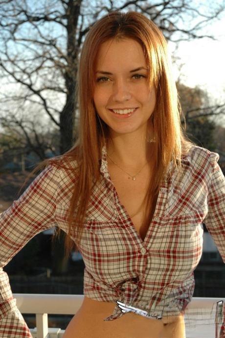 Redheaded country girl models non nude in tied up shirt and denim jeans 41174189