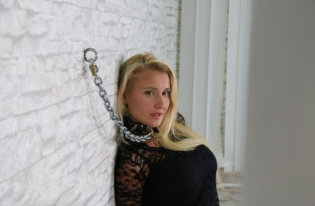 Fully clothed blonde is fastened to a wall with chains in handcuffs 87488577