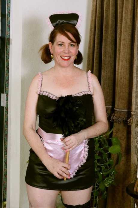 Mature lady Caitlin Moore removes maid uniform to model naked in stockings 16376148
