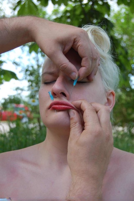 Blonde female sports red lips during needle play in the backyard 26614952