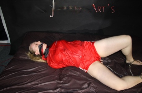 White chick is left restrained on a bed in a raincoat and nylon booty shorts 70857620