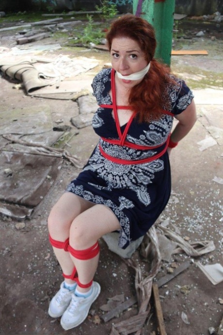 Redhead BBW finds herself gagged & tied to a post while clothed in a warehouse 52148207