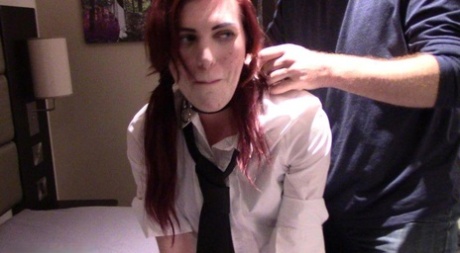 Redheaded coed has pink clothes pegs attached to her tongue while collared 65178611