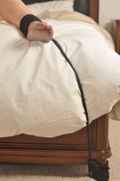 Pretty teen struggles against a horse bit while tied up in the nude on a bed 57930606