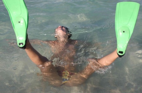 Long legged girl shows the soles of her feet after snorkeling while topless 84051979